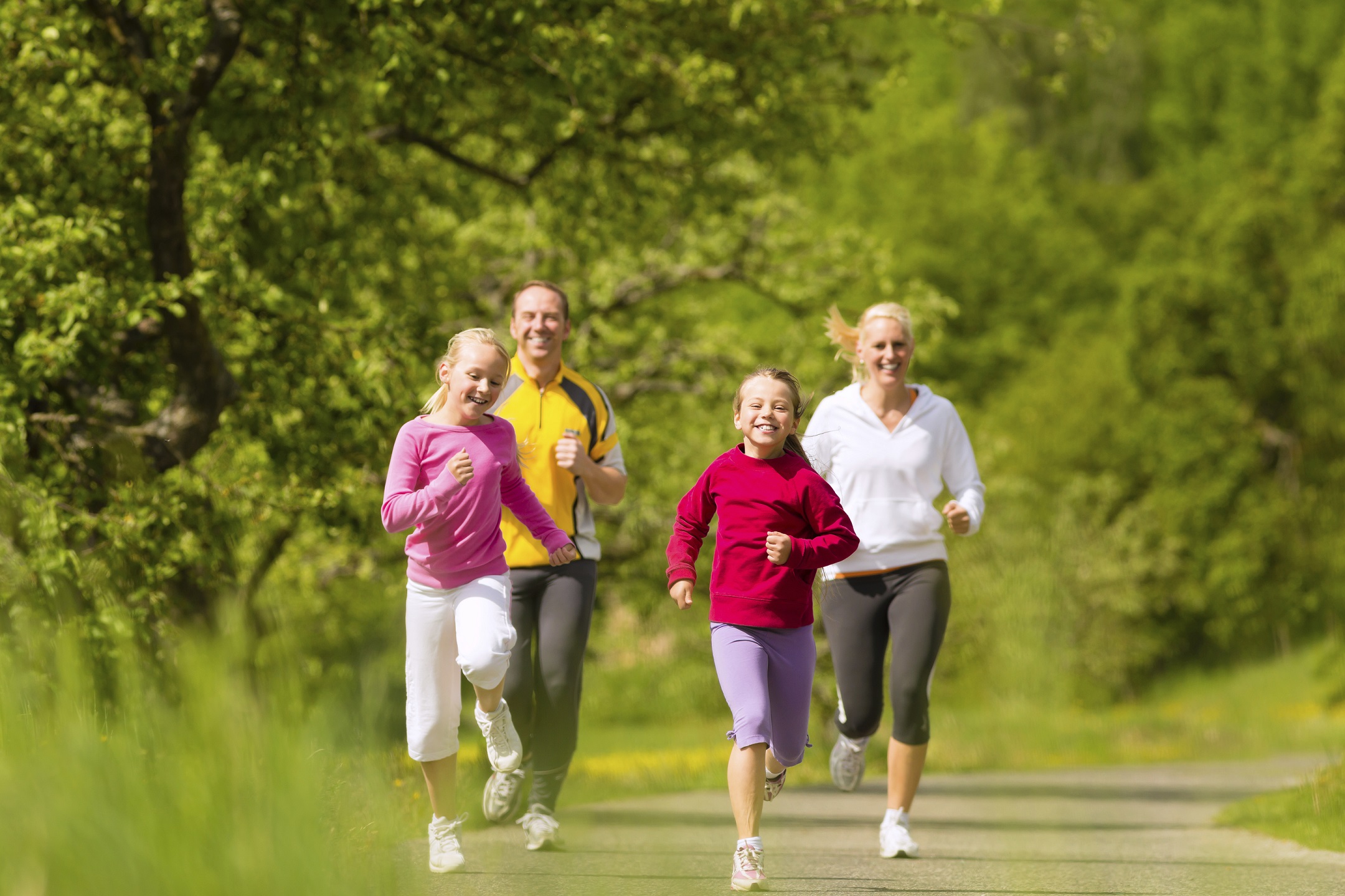 Family jogging for sport outdoors with the kids on summer day