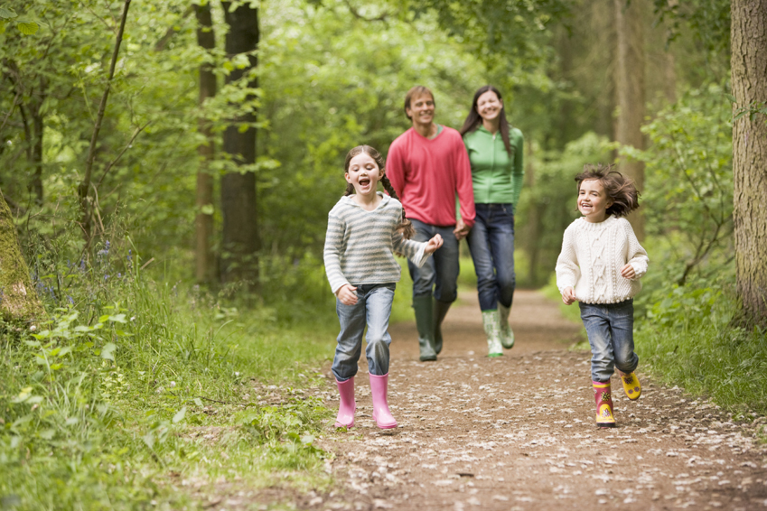 Family walking on path holding hands smiling
