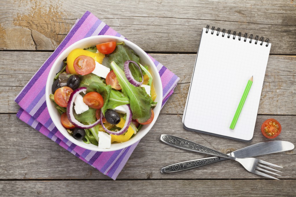 Fresh healthy salad and notepad for copy space
