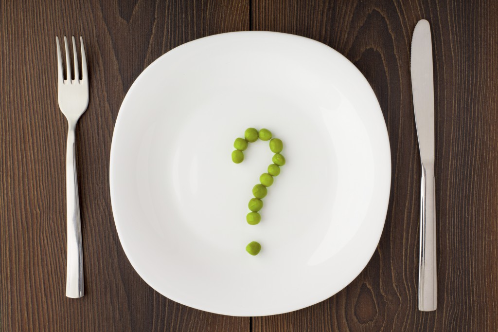 Question mark made of peas on a white plate