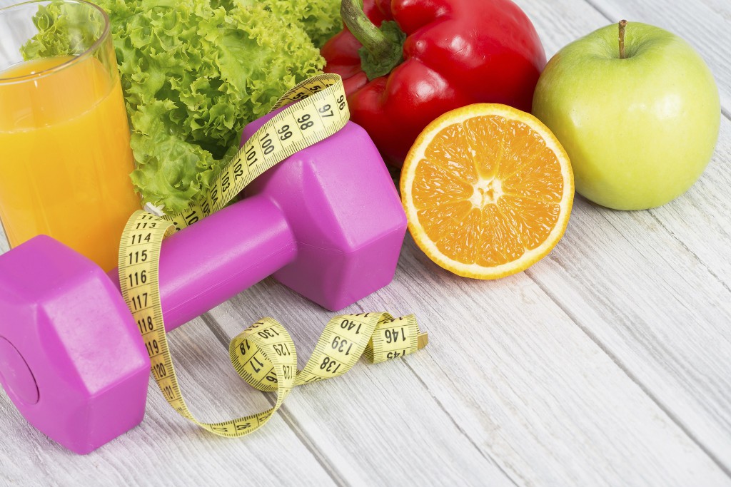 Fitness concept with dumbbells and healthy food.