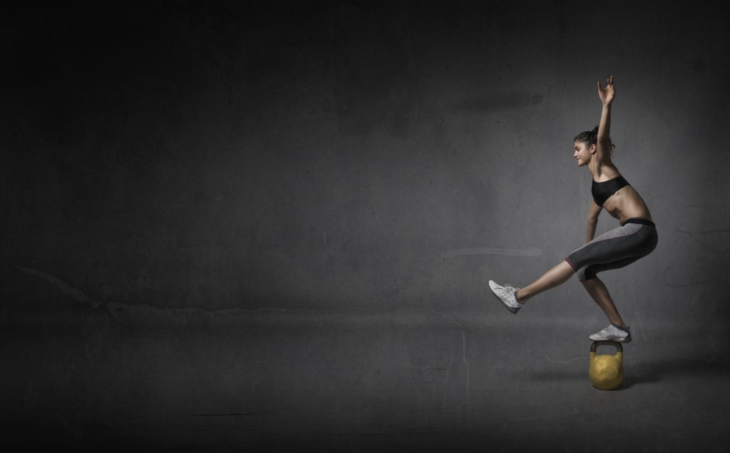 balance on a kettlebell, dark background