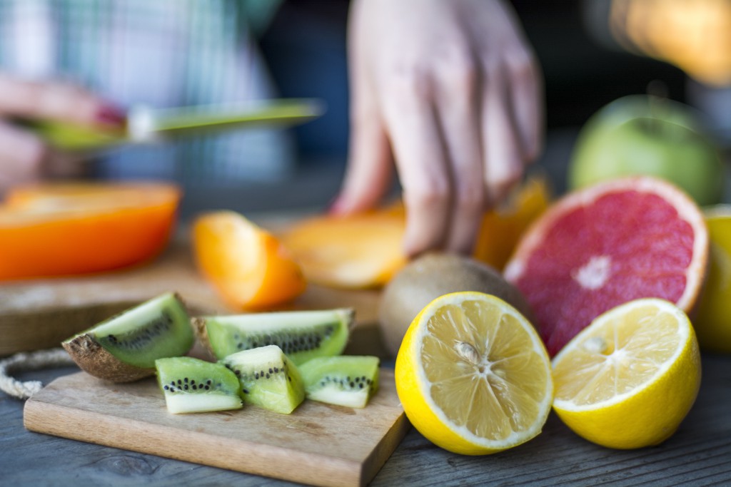 Woman's hands cuts fresh persimmons