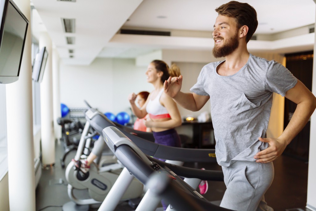 People running on treadmill in gym doing cardio workout
