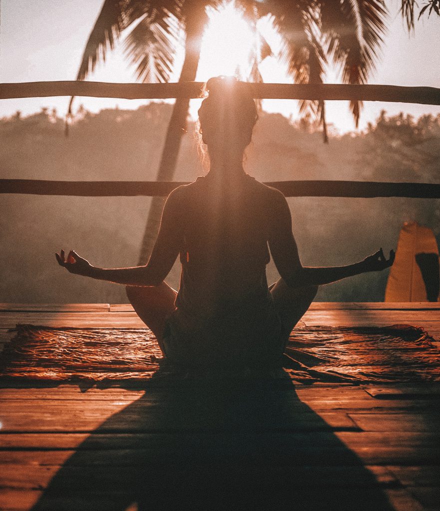 Femme en méditation sur un balcon au soleil