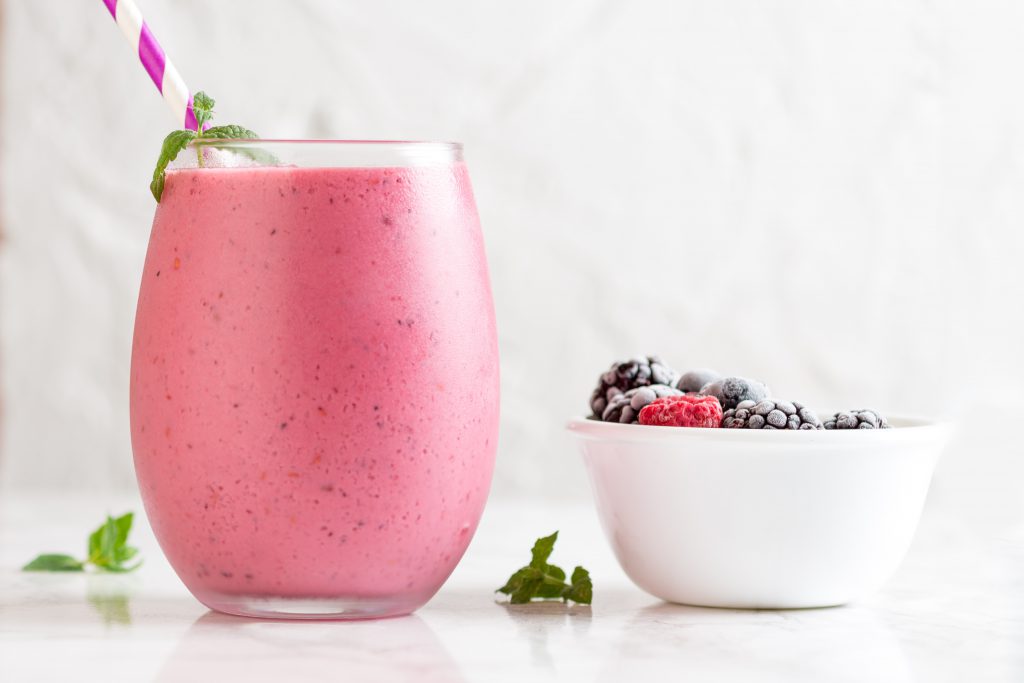Verre de smoothie et bol de petits fruits